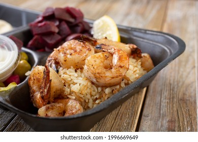 A Closeup View Of A Shrimp Kabob Combo In A Styrofoam To-go Container.