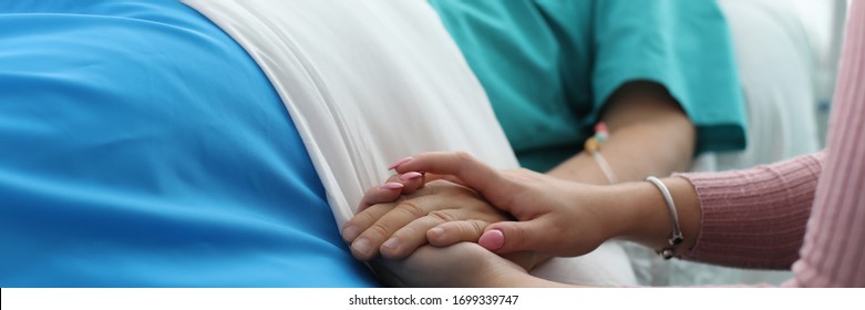 Close-up View Of Sick Person And Family Member Supporting And Wishing Speedy Recovery. Doctor Comfort Patient And His Wife. Intense Treatment At Hospital Concept