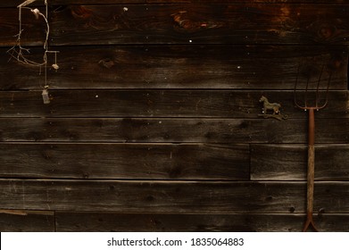 A closeup view of the side of an old barn with some tools and trinkets.