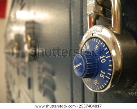 Close-up view of silver and blue lock and metallic blue lockers illuminated by warm lighting with blurry background