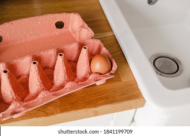 Close-up View Of A Single Raw Chicken Egg In Egg Box On A Kitchen Wooden Counter