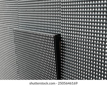 A close-up view of a single square LED module that has not taken its place on the surface of a large LED screen.