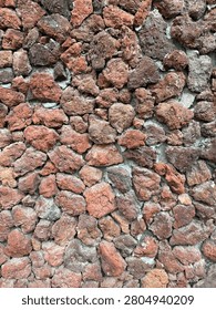 Close-up view of small brown and red pebbles forming a textured stone path.