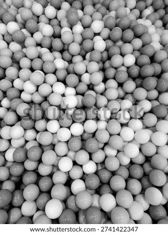 Close-up view of small, spherical plastic balls filling the entire frame, creating a vibrant and playful visual texture. The balls color are pastel hues: soft bubble gum, pink, light lavender.