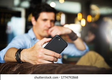 Closeup view of smartphone in male hand. Selective focus. Man using phone in cafe. - Shutterstock ID 1774792868