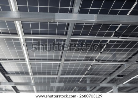 Close-up view of solar panel structure and wiring from underneath. Concept of clean energy, photovoltaic system, renewable power technology, and sustainable infrastructure design.