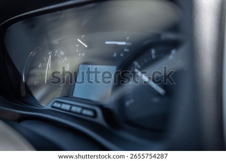 Close-up view of a speedometer displaying a speed of 37 while driving on a clear day, showcasing the dashboard of a compact vehicle.