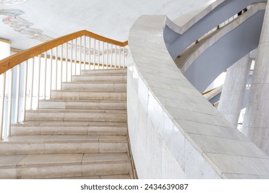 Close-up view of spiral staircase with marble steps and wooden railing inside of building. Soft focus. Copy space for your text. Architecture details theme. - Powered by Shutterstock