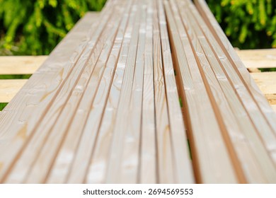A close-up view of a stack of fresh, untreated lumber boards. Ideal for construction and DIY projects, showcasing natural grain and texture for various woodworking designs.