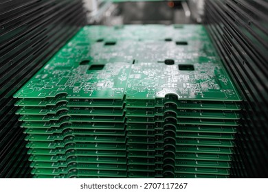 Closeup view of stack of green printed circuit boards in modern electronics manufacturing plant concept of technology industry production