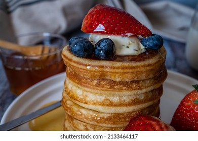 Closeup View Of Stack Of Pancakes With Honey, Strawberry, Blue Berry And Whip Cream On Top In Plate, Delicious Dessert For Breakfast.