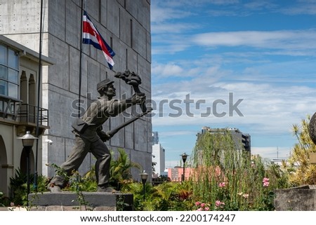 Closeup view of the statue -monument of the national hero  Juan Santamaria- next to the Costa Rica Flag