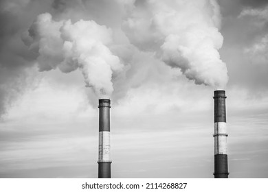 Closeup view steam coming out of pipes of thermoelectric power station in winter time.Termal power industry and environmental pollution concept, black and white image