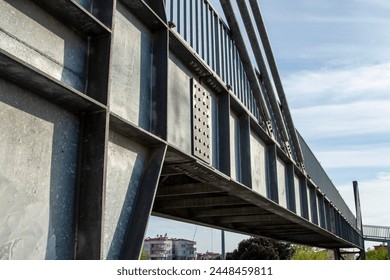 Close-up view of the steel structure of a modern bridge. Close-up of metal fence on the street. Detail of a steel bridge with blue sky in the background. - Powered by Shutterstock