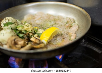 A Closeup View Of A Stove Top Pan Cooking A Shrimp Entree.