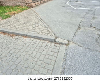 A close-up view of a street intersection featuring cobblestone and asphalt surfaces, representing urban infrastructure and road design in an outdoor setting.