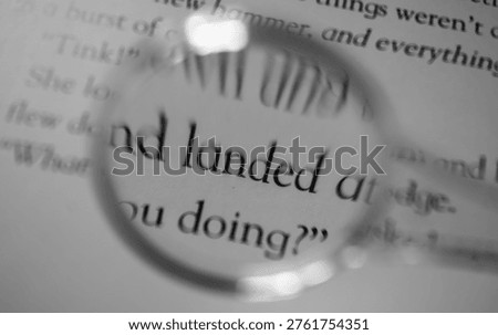 Close-up view of “LANDED” text through magnifying glass