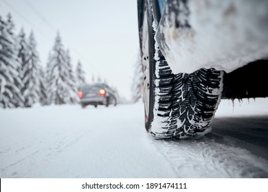 Close-up View Of Tire Of Car On Snow Covered And Icy Road. Themes Safety And Driving In Winter.