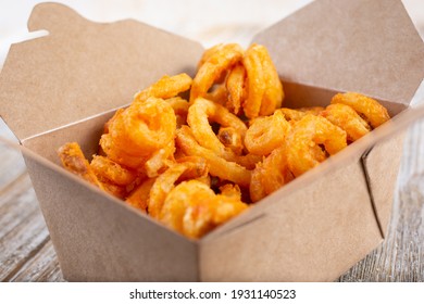 A Closeup View Of A To-go Carton Of Curly Fries.