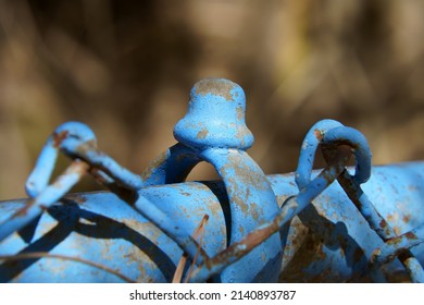 Closeup View Of Top Of Rusty Fence Post Painted Blue