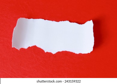 Close-up view of torn piece of paper for ??message on red