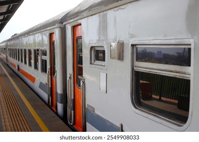 A close-up view of a train car parked at a station platform in Indonesia.