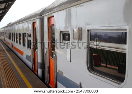 A close-up view of a train car parked at a station platform in Indonesia.
