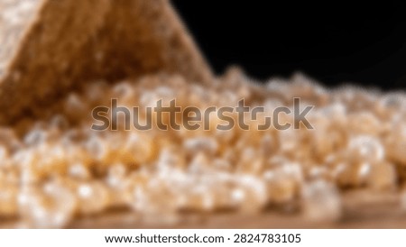 A close-up view of translucent plastic polymer granules spilling from a container, representing industrial manufacturing and raw material processing.