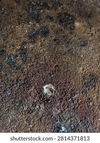 A close-up view of a used firebrick surface showing heat stains, scorch marks, and rough texture.