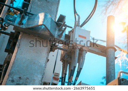 Close-up view of a utility pole featuring various equipment and cables. This image highlights the essential infrastructure for electricity and communication services.