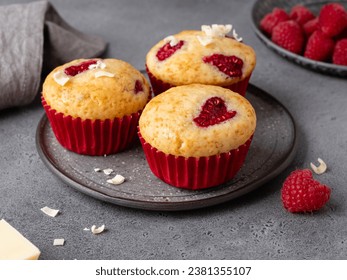 Closeup view of vanilla muffins decorated with heart shaped raspberry. Bright dessert for celebration of saint valentine's day. Grey background. Festive bakery, sweet gift or present for 14 february.  - Powered by Shutterstock