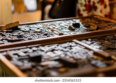 Close-up view of vintage wooden typography blocks in a printer's tray, showcasing classic printing techniques. The image highlights the artistic heritage and creative atmosphere of an artisan workshop - Powered by Shutterstock