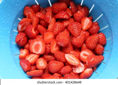 Close-up view of washed strawberries reflecting in a blue pot. - Powered by Shutterstock