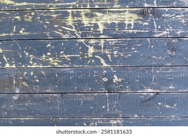 Close-up view of weathered blue wooden planks revealing a textured surface with scratches, remnants of old paint, and signs of age, creating a rustic and vintage backdrop
