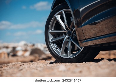 Close-up view of wheel of sports car at the gravel road - Powered by Shutterstock