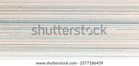 A close-up view of a white surface with thin, slightly colored lines woven together creating a patterned background. Macro photo of closed book pages, paper texture from the front, background