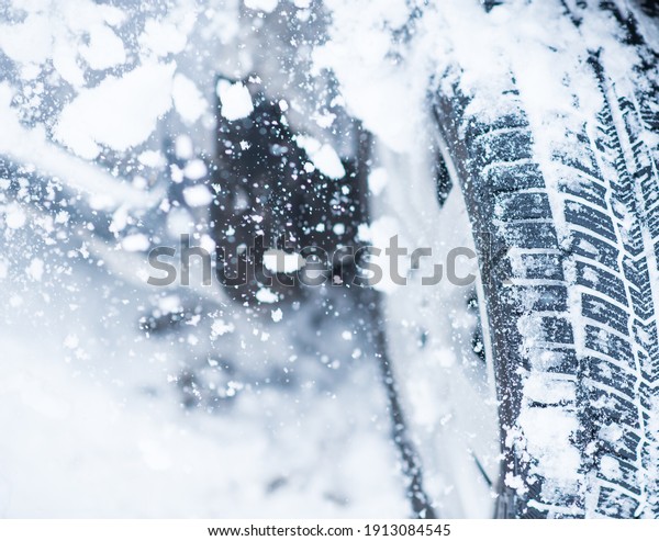 Closeup view of winter tires on a road
covered with snow in cold freeze winter
months.