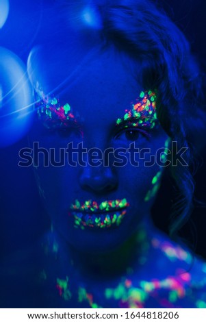 Close-up view of woman with colorful fluorescent make-up 