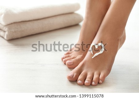 Closeup view of woman with cream on her foot indoors, space for text. Spa treatment