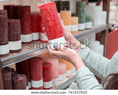 Closeup view of woman hands choosing festive decorative candles for Christmas or New Year celebration