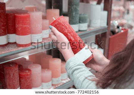 Closeup view of woman hands choosing red festive decorative candles for Christmas or New Year celebration