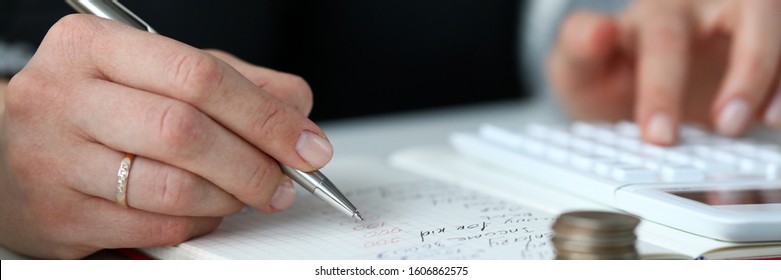 Close-up view of woman managing finances and reviewing bank account. Coins on table. Shot of person calculating money and writing down. Economical concept - Shutterstock ID 1606862575