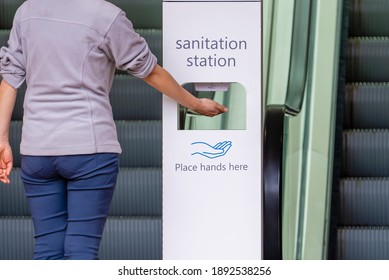 Close-up View Of Woman Sanitizing Her Hands At Sanitation Station Outside A Shopping Mall