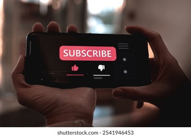 Close-up view of a woman using a smartphone to press red subscribe button on online media. Concepts of technology and following news, hot trends and new content on social media - Powered by Shutterstock