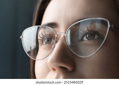Closeup view of woman wearing eyeglasses on blurred background