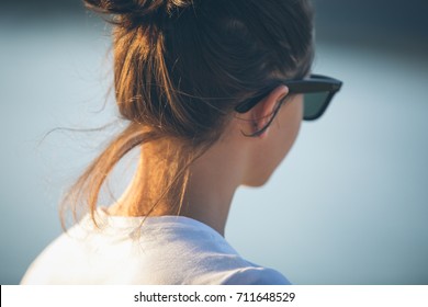 Close-up view of the woman's back with her hair up in a pony-tale
				
