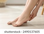 Closeup view of woman`s groomed feet after care procedure on floor