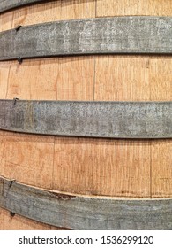 Close-up View Of A Wooden Barrel With Metal Ring Strips Peeling Off The Paint.