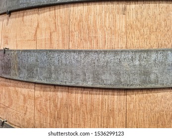 Close-up View Of A Wooden Barrel With Metal Ring Strips Peeling Off The Paint.