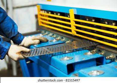 Close-up view of worker's hand at workshop operating guillotine shears machine - Powered by Shutterstock